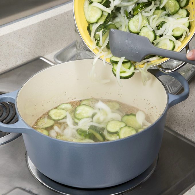 Drained Cucumbers Being Added To Dutch Oven
