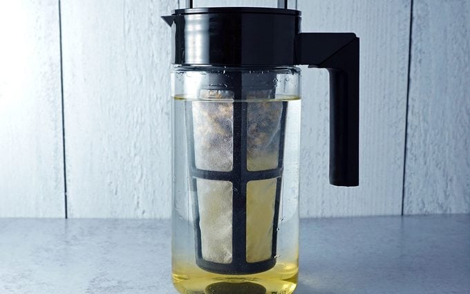 a cold brew pitcher of water with tea leaves and tea bags just added to steep for cold brew tea