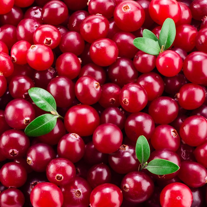 Cranberry with leaves. Red background.