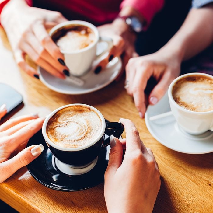 Closeup of hands with coffee cups in a cafe