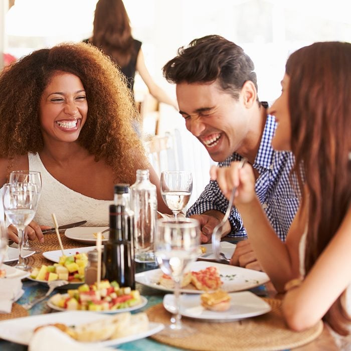 Group Of Young Friends Enjoying Meal In Outdoor Restaurant