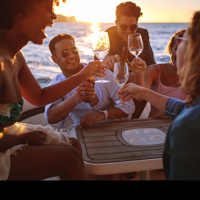 Friends cheering over wine at sunset