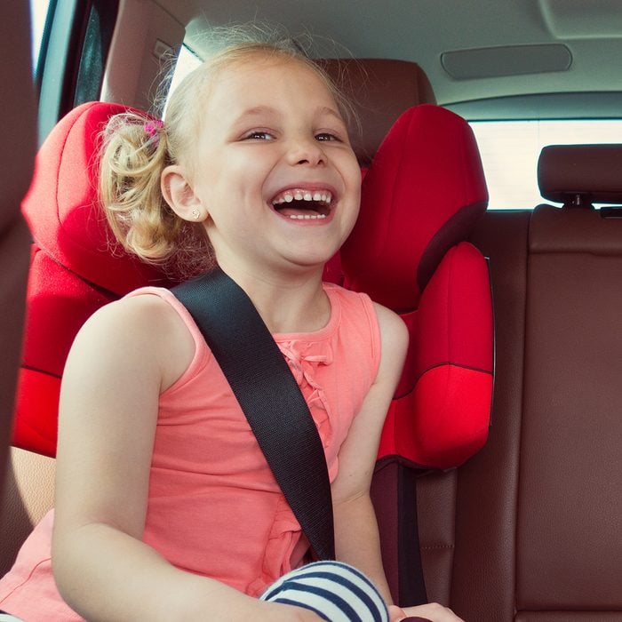 Adorable kid laughing in their car seat