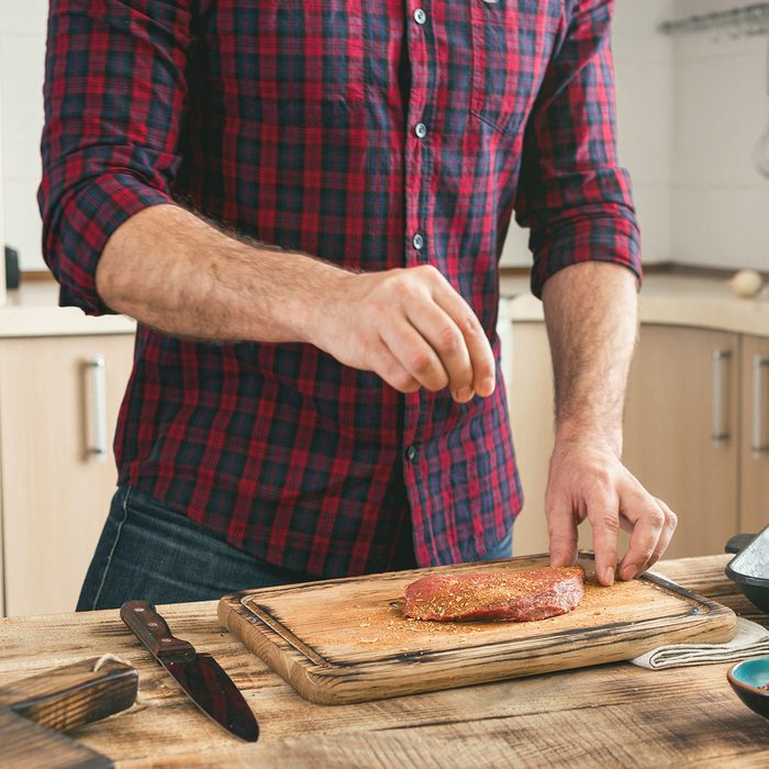 Man cooking grilled steak on the home kitchen.