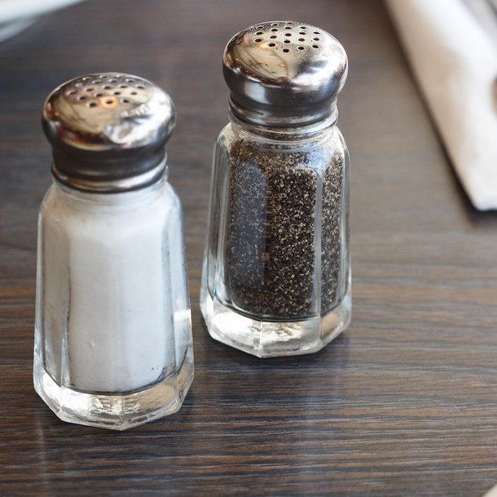 Breakfast scene at a diner with salt and pepper shakers, silverware, and coffee