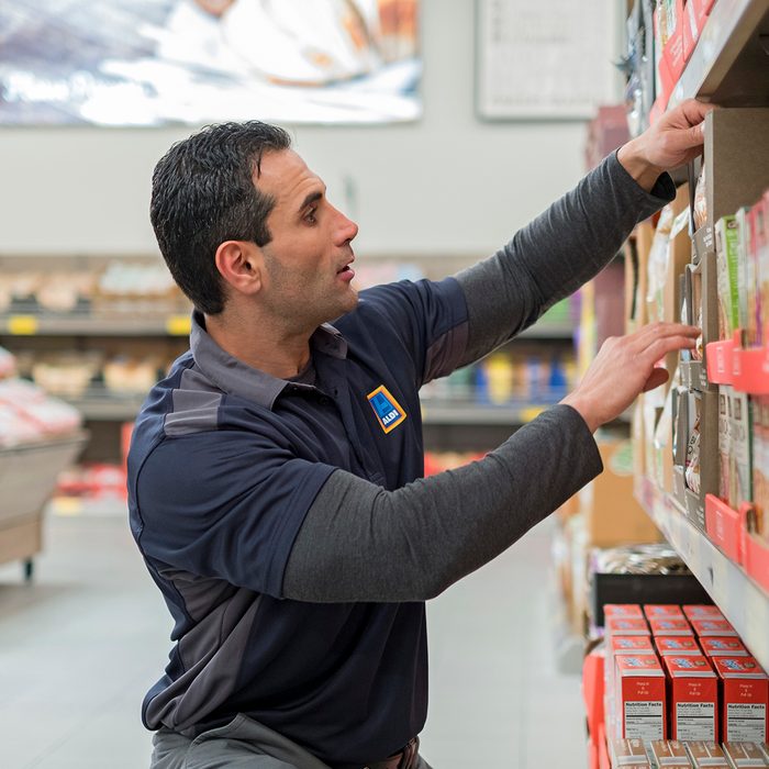 Aldi employee stocking shelf