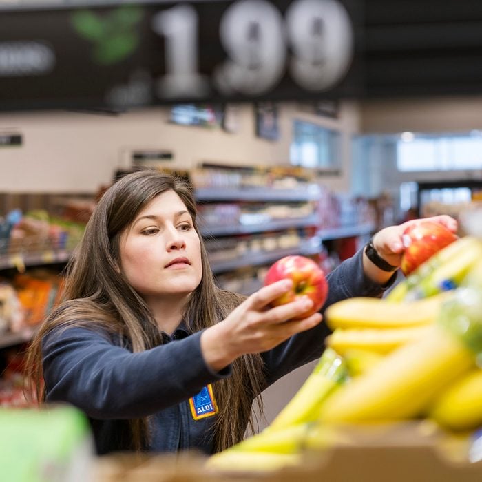 Aldi employee stocking produce