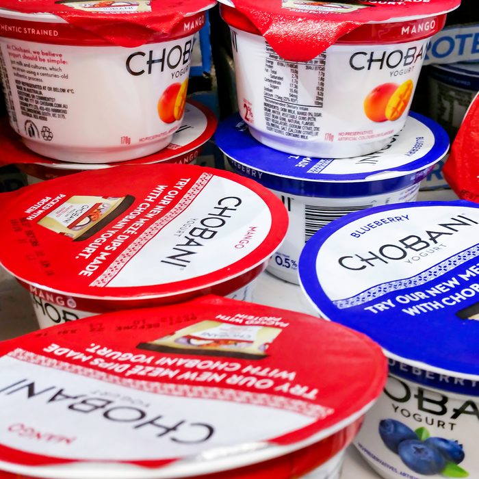 Individual tubs of Chobani brand yogurt on display in a refrigerator for sale in a local supermarket.