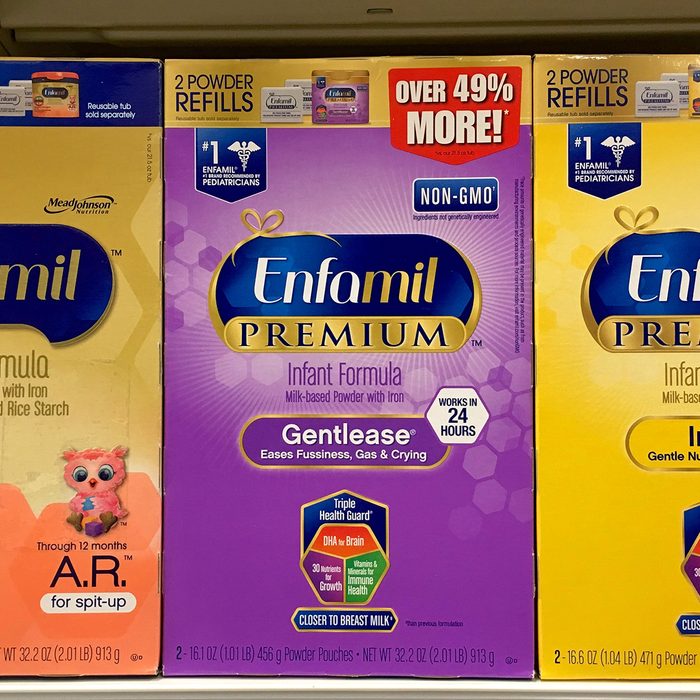 Grocery store shelf with boxes of Enfamil brand baby formula. 