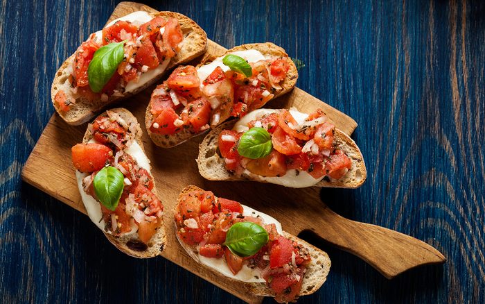 Italian bruschetta (tomato mozzarella basil bread) on a cutting board