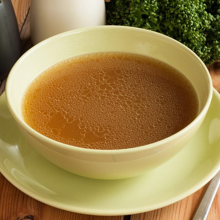 Bone broth made from beef, served in a green soup bowl