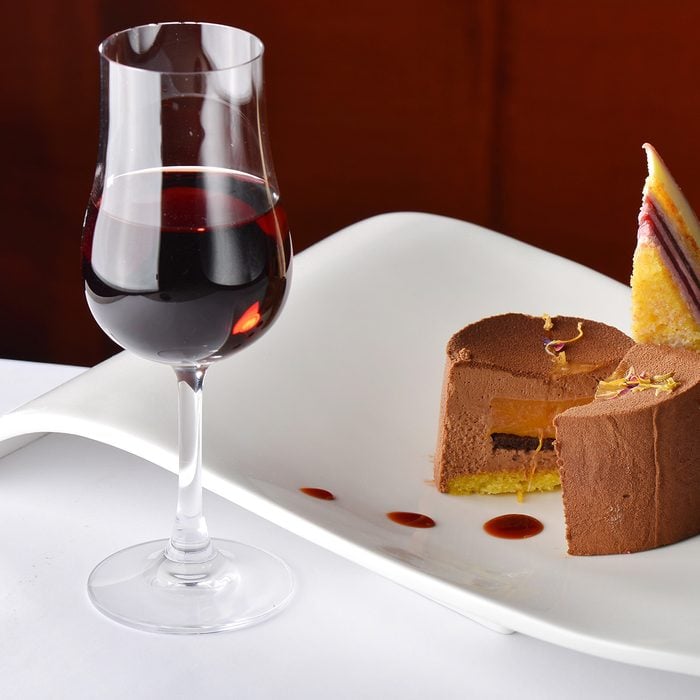 Chocolate and berries cake with glass of dessert wine