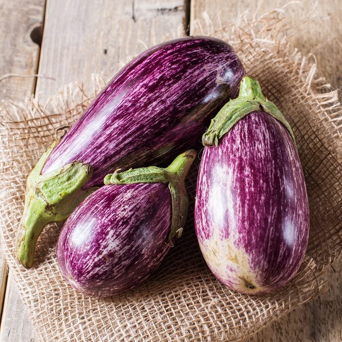 Harvest of striped eggplant on a wooden background