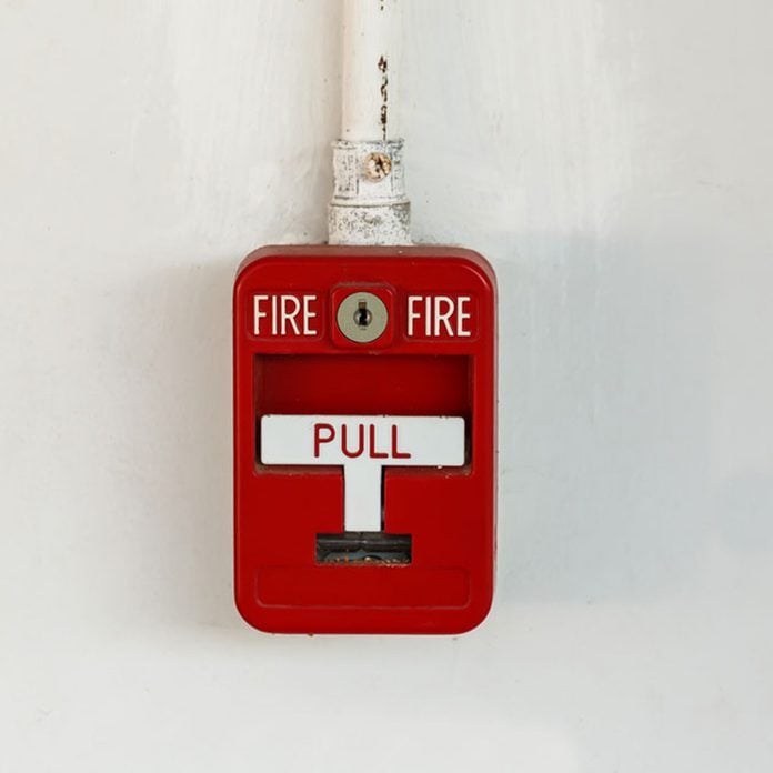 Old red box fire alarm isolated on white background