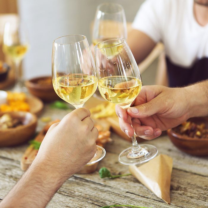 Hands with white wine glasses. Dinner and celebration