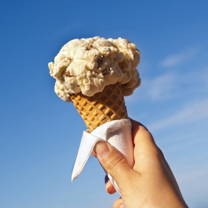 Ice cream cone held up to the hot summer sky