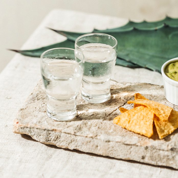 Mezcal or Mescal is a Mexican distilled alcoholic beverage made from any type of oven-cooked agave. With spicy tortilla chips and guacamole dip.