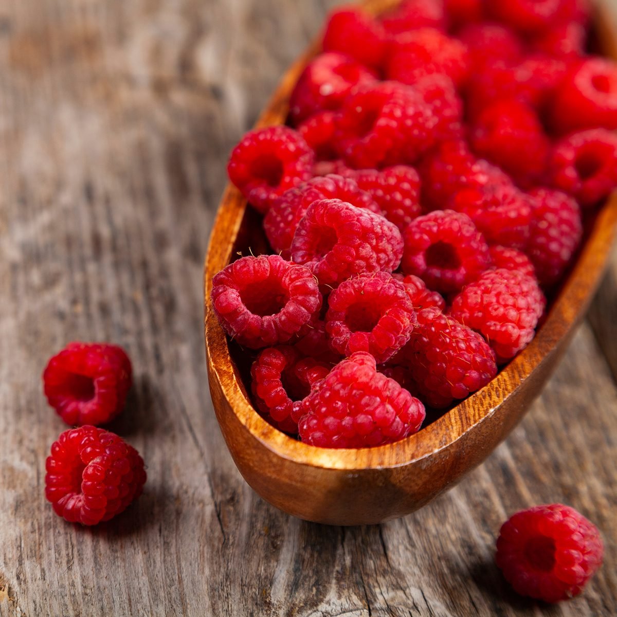 fruits for diabetics Ripe raspberries in a bowl on an old wooden table.