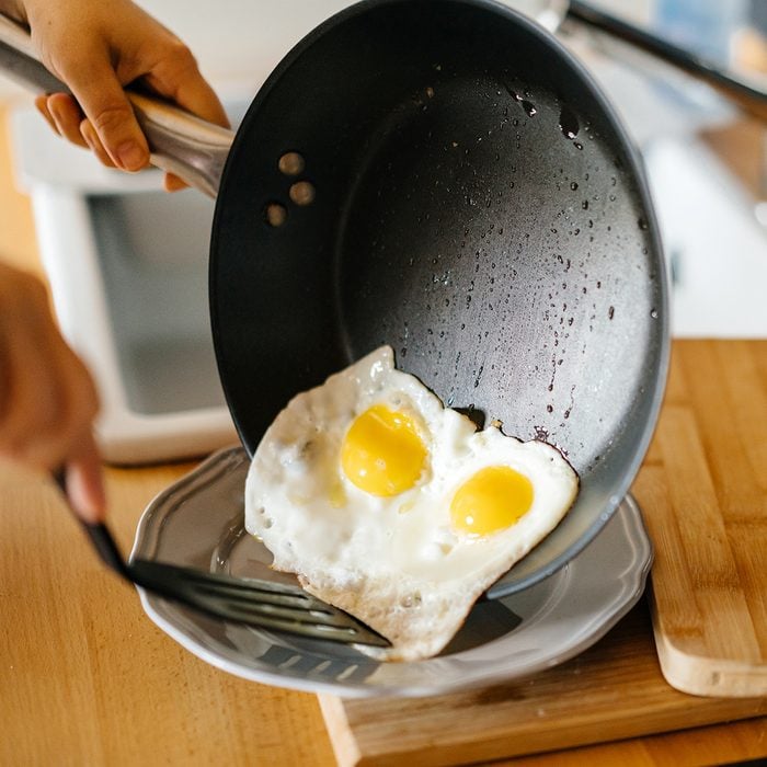 Two fried eggs in a pan with olive oil.