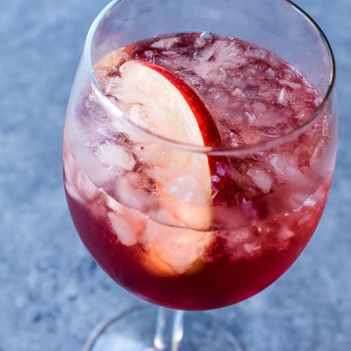 Rose Pink Blush Wine Cocktail with Pomegranate Seeds, Apple Slice and Crushed Ice.