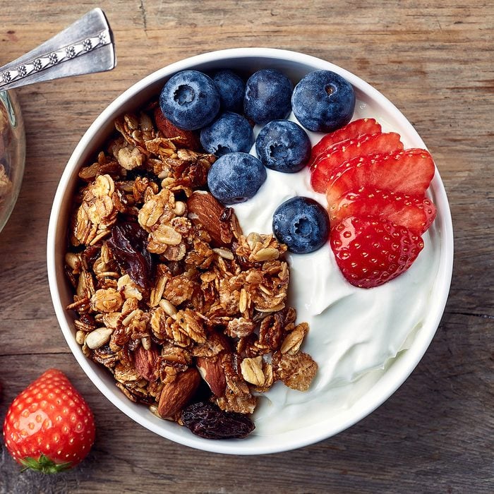 Bowl of homemade granola with yogurt and fresh berries on wooden background from top view; Shutterstock ID 521309641; Job (TFH, TOH, RD, BNB, CWM, CM): TOH