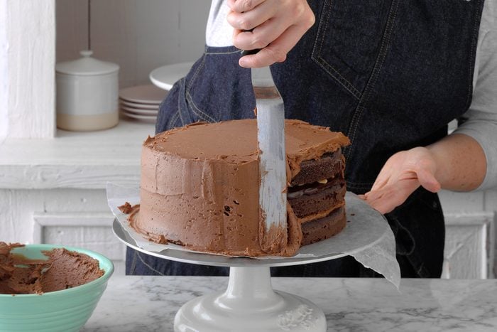 Frosting a chocolate cake
