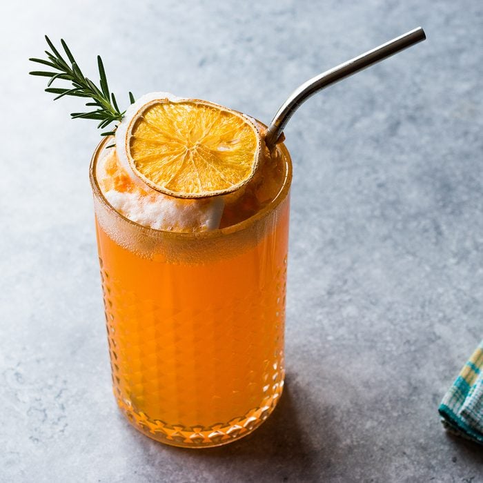 Dried Orange Cocktail with Foam, Rosemary and Metal Straw.