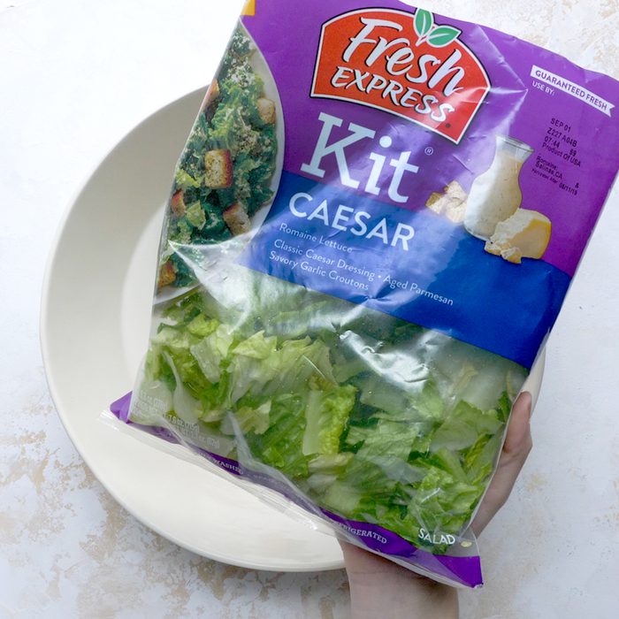 Salad kit over empty bowl