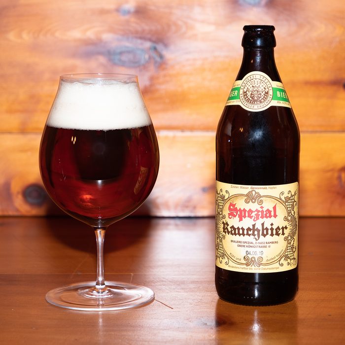 Dark Bamberg Smoked Beer from the famous Spezial Brewery in Bamberg, Bavaria, Germany in the Glass with its Bottle on a wood table.