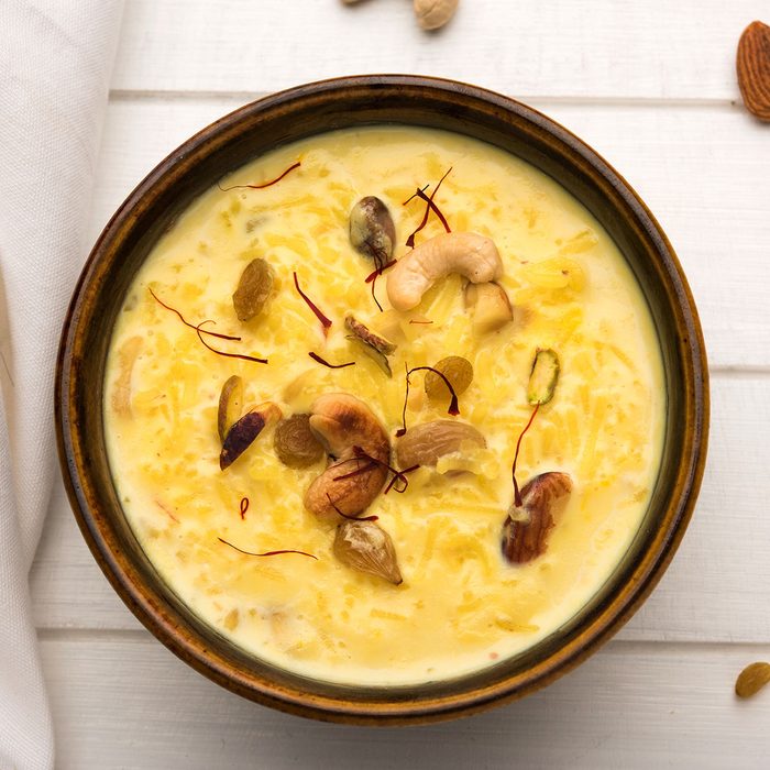 kheer or rice pudding is an Indian dessert in a brown terracotta bowl with dry fruits toppings