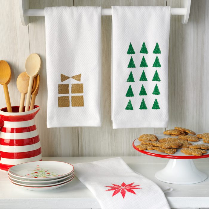 Dress Up The Kitchen by Decorating for Christmas with Holiday Hand Towels, Holiday Plates, Specialized Utensil Holder and Various Christmas Decorations Spread Around Kitchen Prep Areas