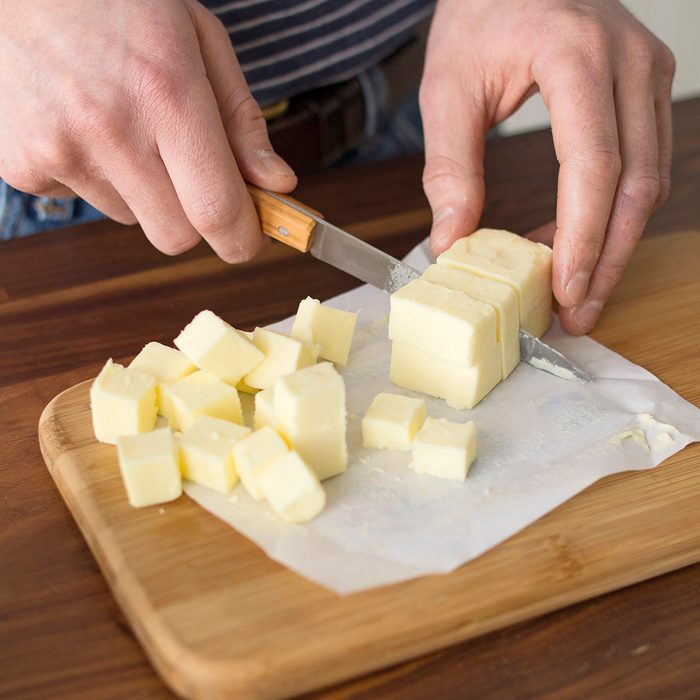Cutting Pieces of Butter on wooden board