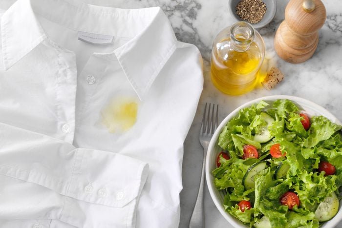 White Shirt Stained With olive oil, pepper, and salad on a marble counter top