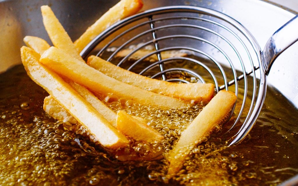 Cooking french fries. Close up of Frying french fries in the fryer in hot oil