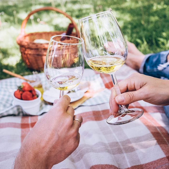 Couple in love drinks a white wine on summer picnic