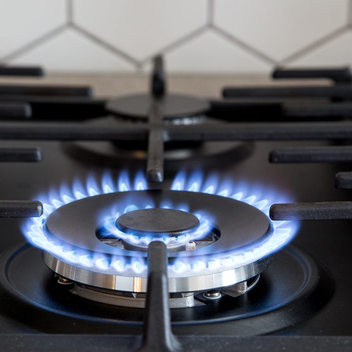 Gas burner on black modern kitchen stove.