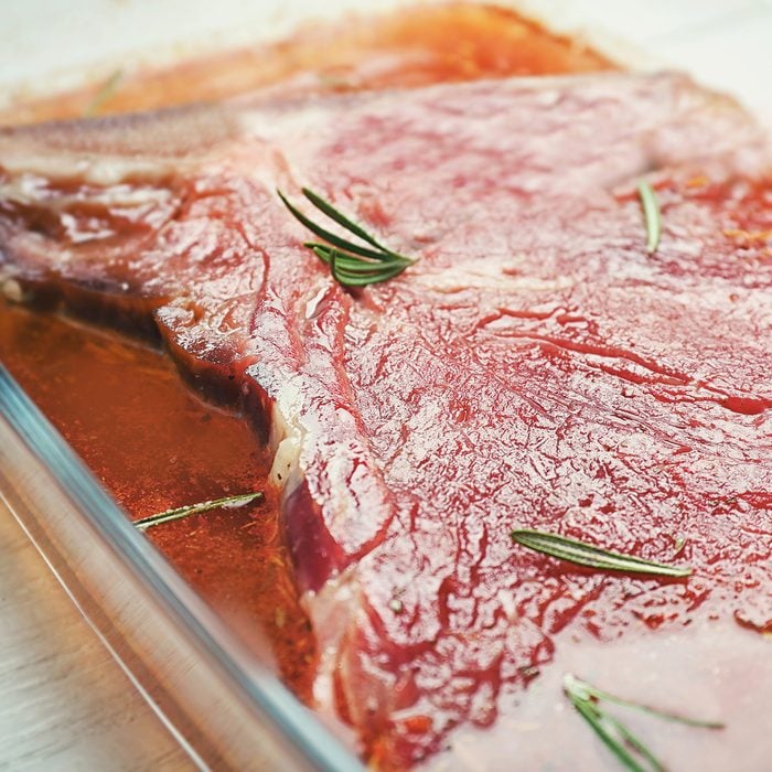 Glass dish with delicious steak in marinade