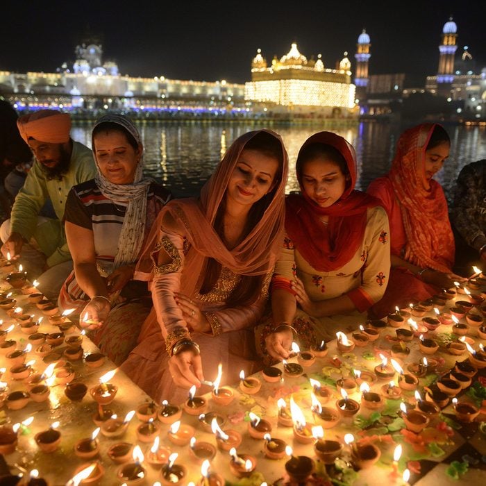TOPSHOT - Indian Sikh devotees light lights diyas (earthen lamps) during Bandi Chhor Divas or Diwali at the Golden Temple in Amritsar on November 7, 2018. - Sikhs celebrate 'Bandi Chhor Divas', also on the same day as the Hindu festival of Diwali, to mark the historic return of the sixth Guru, Guru Hargobind. (Photo by NARINDER NANU / AFP) (Photo credit should read NARINDER NANU/AFP via Getty Images)