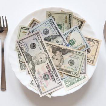 U.S. dollars on a plate with knife and fork.
