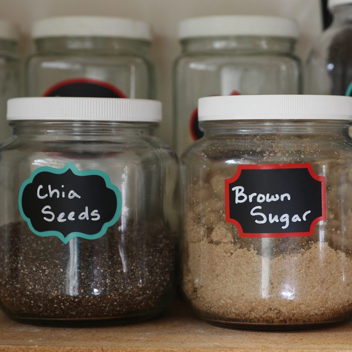 pantry glass jars filled with kitchen staples including oatmeal, brown sugar, and chia seeds on a shelf