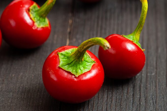 cherry peppers on old black wooden table background