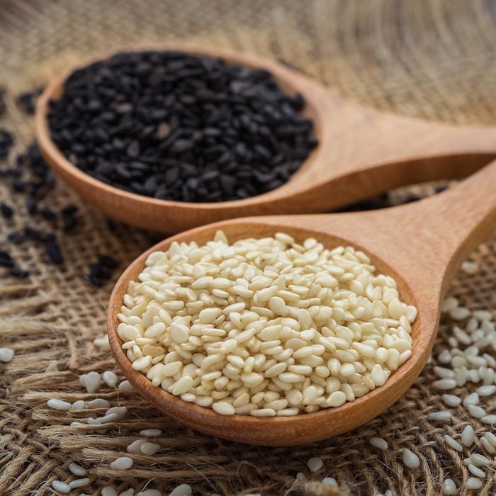 White sesame and black sesame seed on wooden spoon