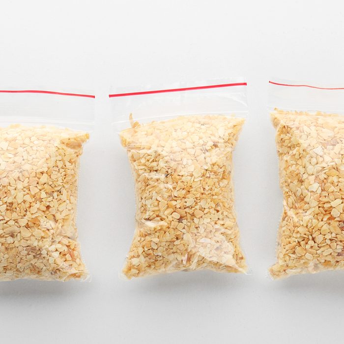 Ziploc bags with granulated dried garlic on white background