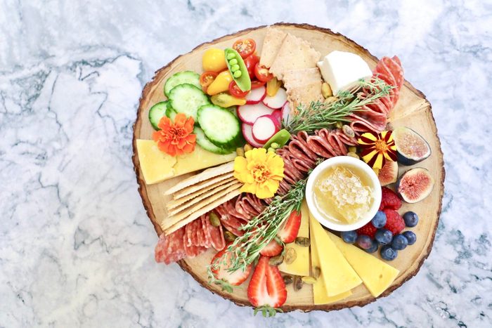 Influencer Marissa Mullen's cheese plates often contain cheese, fruits and veggies, honeycomb, edible flowers and what she calls a "salami river."