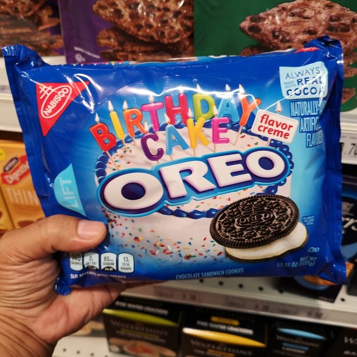 Hand hold a packet of OREO Birthday Cake flavor creme for sell in the supermarket.