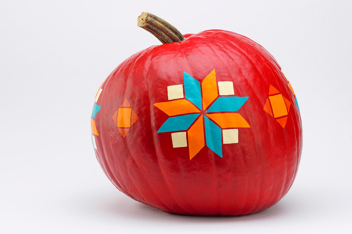 red painted pumpkin with a quilt design
