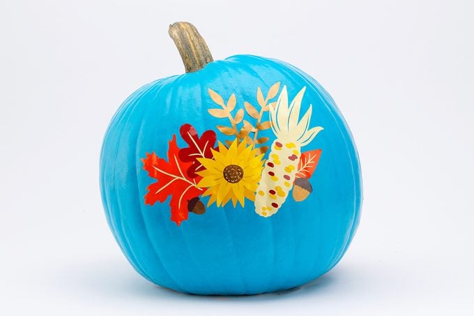 blue painted pumpkin with fall flowers