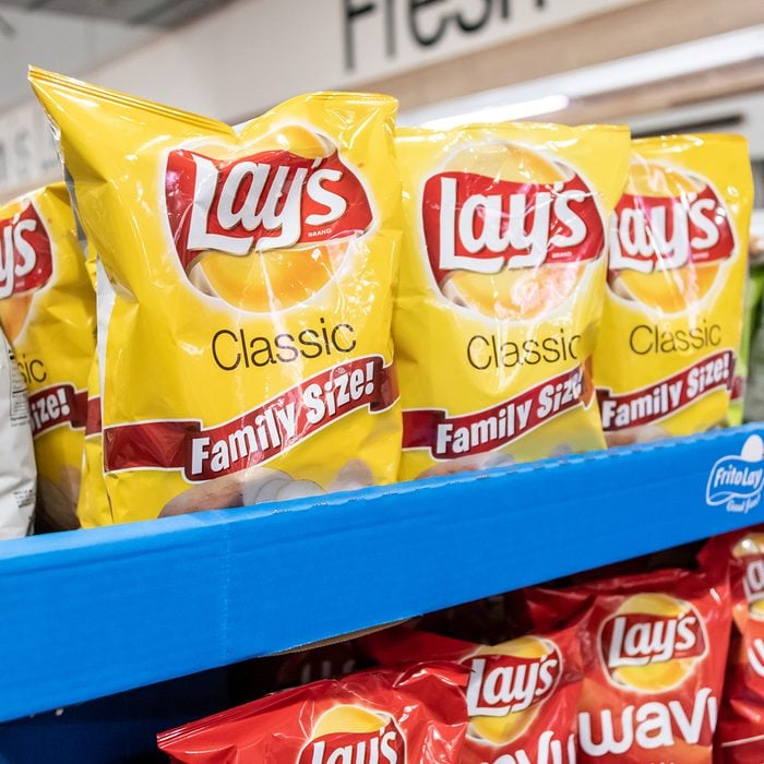 Plastic Bags of Lay's brand potato chips for sale in a supermarket aisle