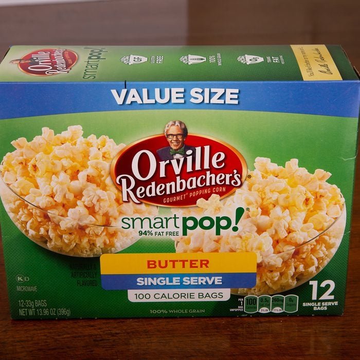 A box of Orville Redenbacher's Smart Pop Buttered Popcorn on a wood table