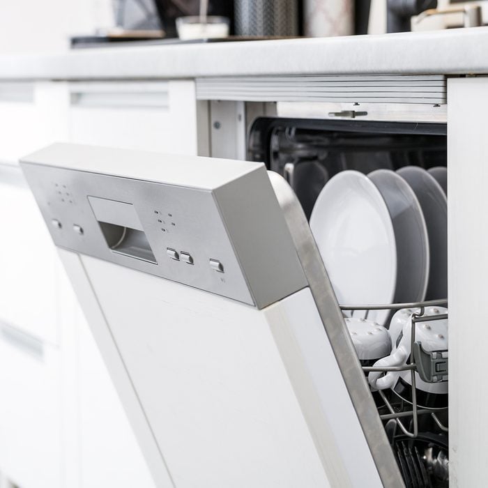 Open dishwasher with clean dishes after washing